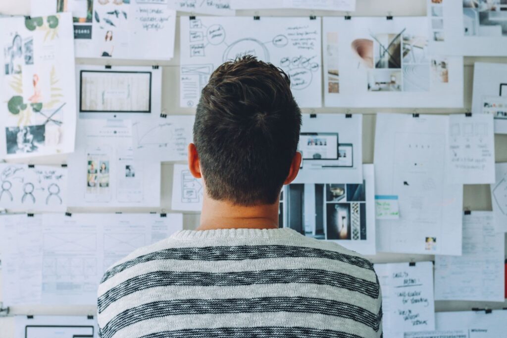 man looking at notes on the wall