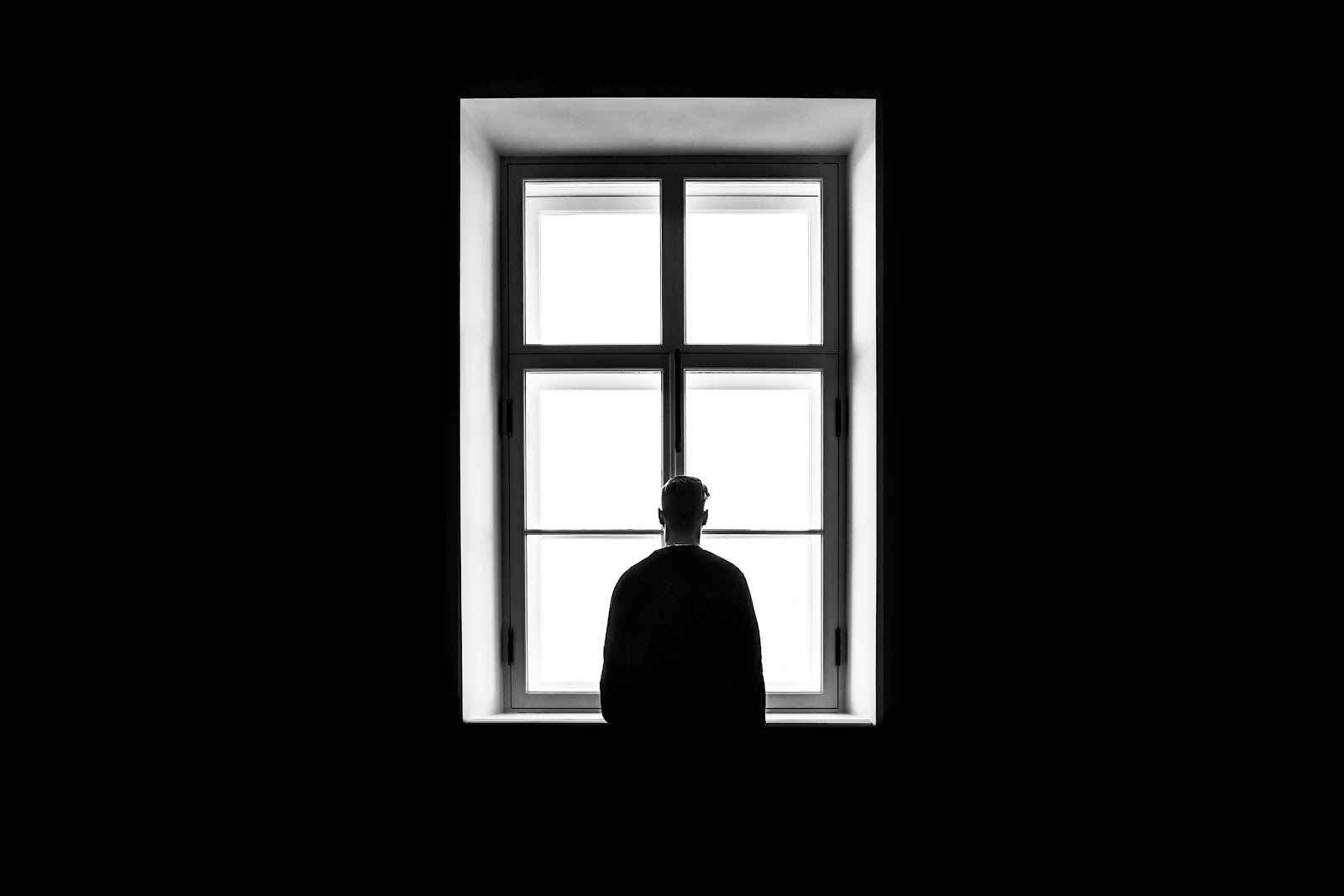 man looking outside from a window