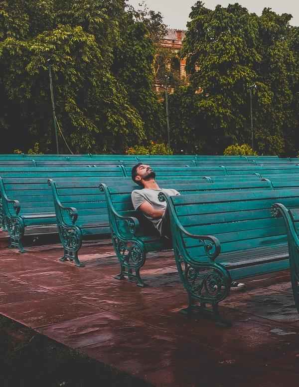 Man sitting with eyes closed on a bench