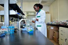 A woman in a lab coat diligently working on a project, showcasing her expertise in the scientific field.