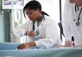 A nurse and doctor collaborate to treat a patient, providing medical care and expertise, and the nurse is looking at her watch.