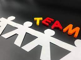 A collage of paper cut-out people forming the word "team".