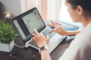 A woman focused on her laptop, typing intently.