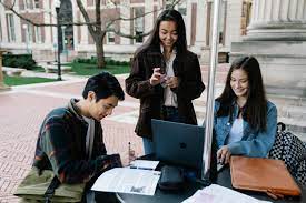 3 college students studying outdoors in the college campus