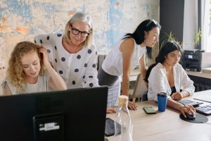 A diverse group of women collaborating in a modern office, brainstorming ideas and working together to achieve their goals.