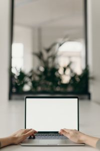 A person working on a laptop at a desk, focused and engaged in their work.