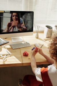 A child focused on the computer screen while sitting at a desk, engaged in learning or working.