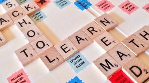 A Scrabble board with words: back, to, learn, mad.