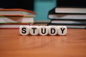 Study materials on a desk with books: word blocks, textbooks, and notes.